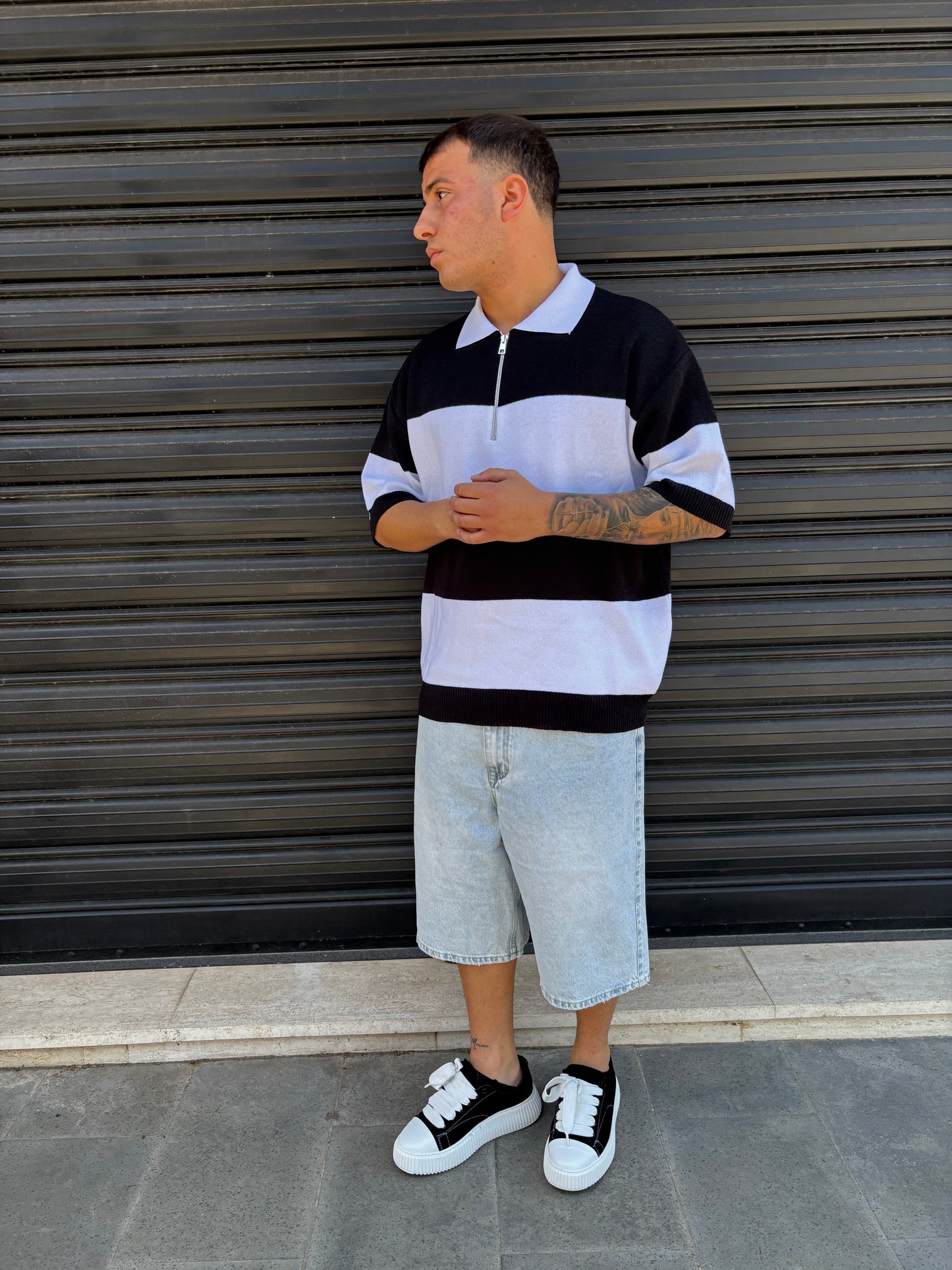 Polo a righe con zip bianca e nera